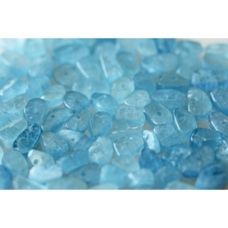 Helle blaue Glaskiesel mit verschiedenen Formen und Größen auf weißem Hintergrund.