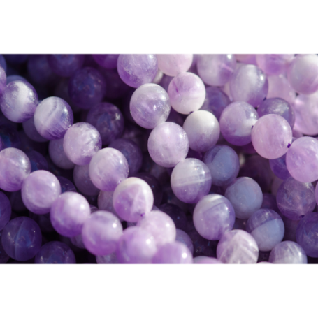 Lila Perlen in verschiedenen Größen und Oberflächenstrukturen.