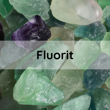 Florit Bunte Fluoritkristalle in verschiedenen Formen und Farben auf schwarzem Hintergrund.
