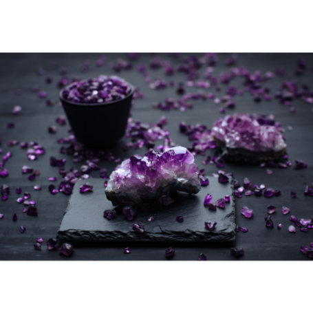 Lila Amethyststeine und -splitter auf einer dunklen Oberfläche.